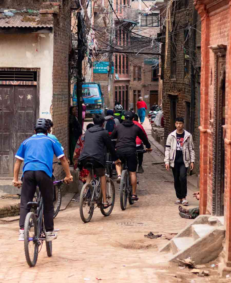 people cycling in alleys if bhaktapur- Cycle connects Bhaktapur